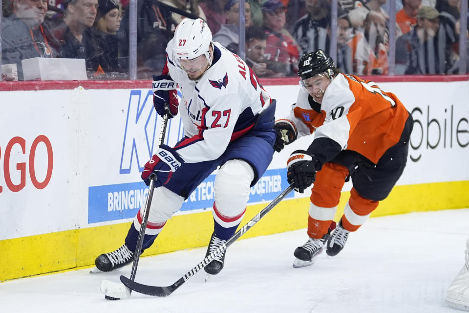 Washington Capitals' Alexander Alexeyev, left, tries to keep the puck away from Philadelphia Flyers' Bobby Brink during the second period of an NHL hockey game, Tuesday, April 16, 2024, in Philadelphia. (AP Photo/Matt Slocum)