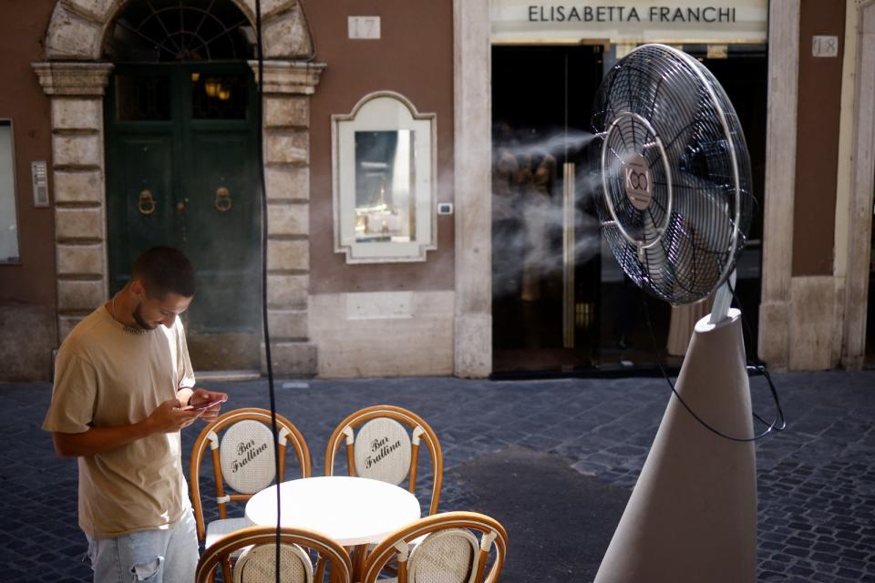 去年7月熱浪中的義大利羅馬，民眾在街頭用水冷涼風扇降溫。路透社