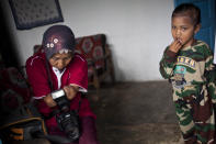 PURWOREJO, INDONESIA - MARCH 14: Armless professional photographer Rusidah, 44, prepares camera before taking a customer's portrait on March 14, 2012 in Purworejo, Indonesia. Rusidah shoots weddings and parties and has a small studio at home in the village of Botorejo, Bayan District, Purworejo, Central Java where her husband and son also reside. She has been in the photography business for nearly 20 years. (Photo by Ulet Ifansasti/Getty Images)