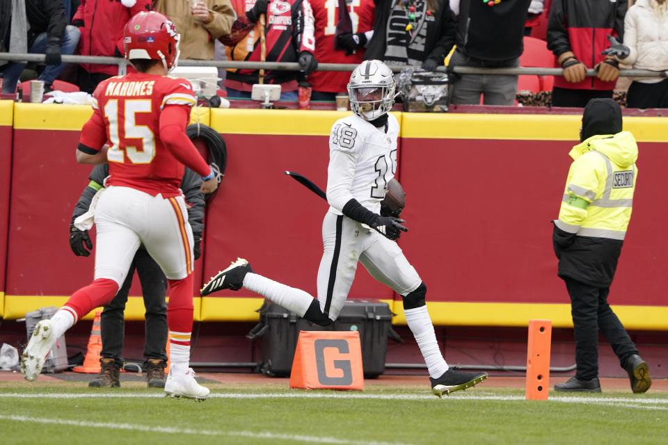 Las Vegas Raiders cornerback Jack Jones scores after intercepting a pass and running it back for a touchdown as Kansas City Chiefs quarterback Patrick Mahomes (15) watches during the first half of an NFL football game Monday, Dec. 25, 2023, in Kansas City, Mo. (AP Photo/Ed Zurga)