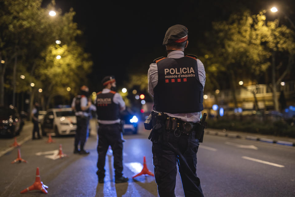 BARCELONA, SPAIN - OCTOBER 25: Police officers stand on patrol on the first night of a countrywide curfew on October 25, 2020 in Barcelona, Spain. Spain has declared a national state of emergency and imposed a night-time curfew from 11pm to 6am in an effort to help control a new spike in coronavirus (COVID-19) infections. (Photo by Xavi Torrent/Getty Images)