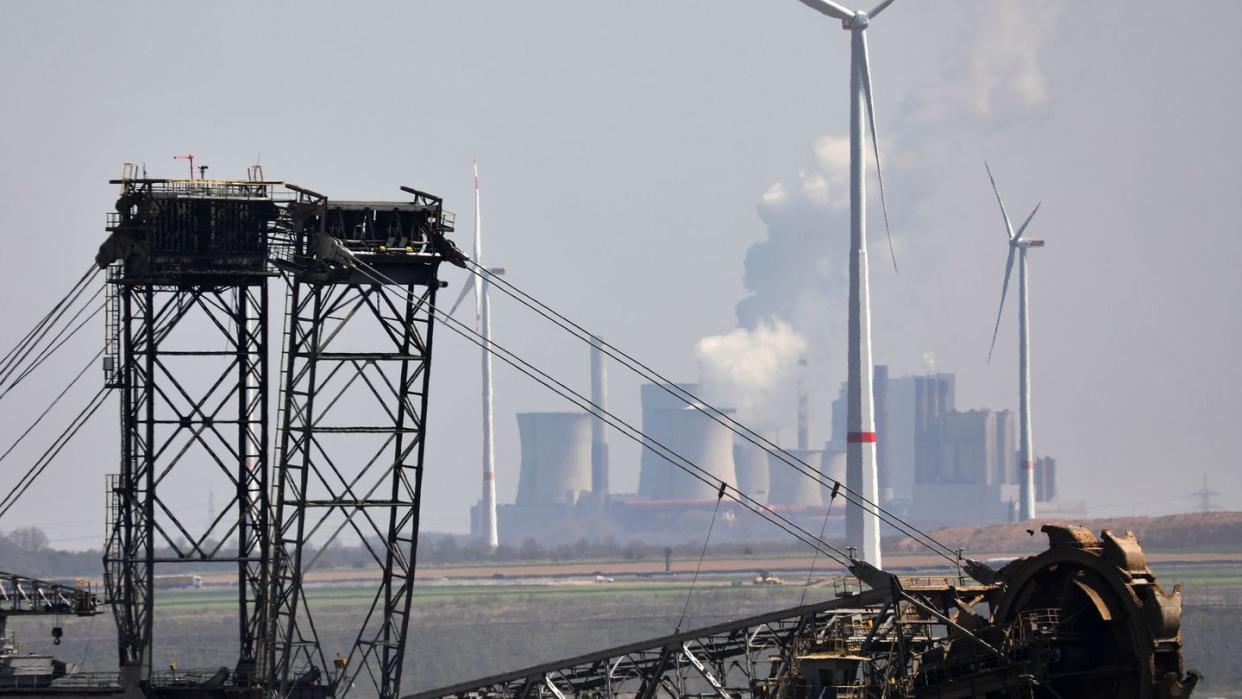 Ein Bagger gräbt am Tagebau Garzweiler, im Hintergrund das Braunkohlekraftwerk Niederaußem - und Windräder. Viel Zeit für ein neues Klimaschutzgesetz bleibt nicht. Die letzte Sitzungswoche des Bundestags vor der Wahl im September ist Ende Juni.