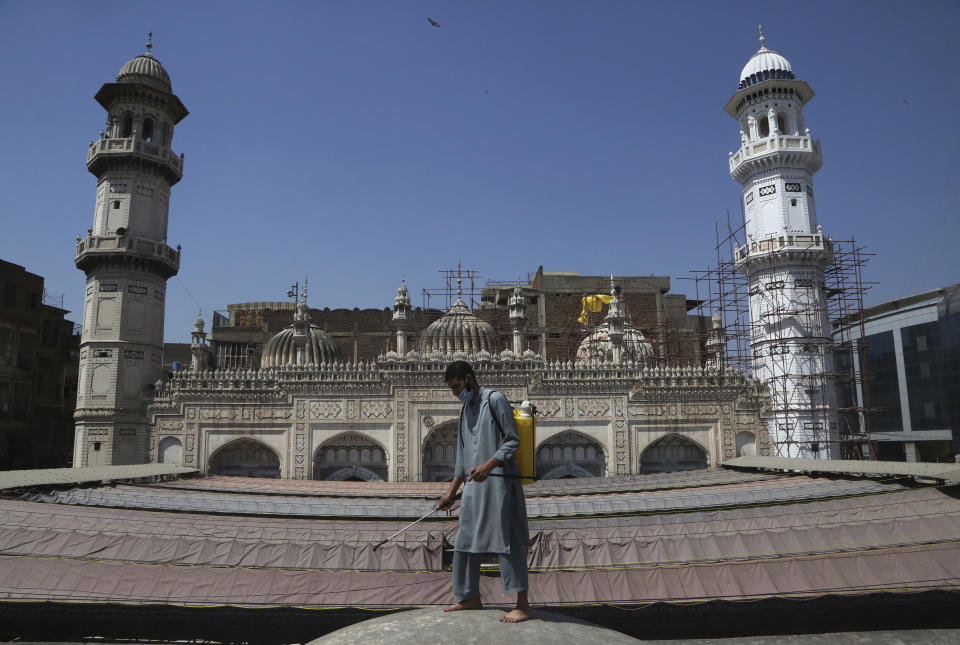 A volunteer disinfects the outer area of a historical Mohabat Khan mosque ahead of the upcoming Muslim fasting month of Ramadan, in Peshawar, Pakistan, Friday, April 9, 2021. (AP Photo/Muhammad Sajjad)