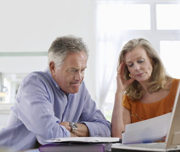 A visibly concerned mature couple examining their finances.