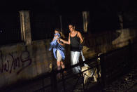 <p>Two women evacuate the village of Mati during a wildfire near Athens, on July 23, 2018. (Photo: Angelos Tzortzinis/AFP/Getty Images) </p>