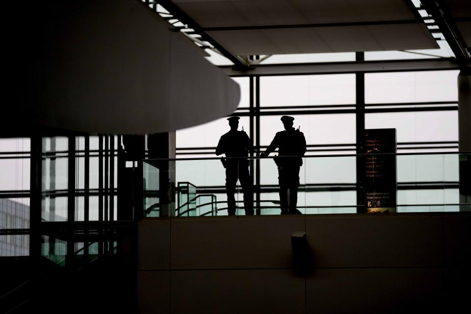 Police officers guard the deserted departure terminal during a strike in Bavaria at the airport in Munich, Germany, Sunday, March 26, 2023. An increased number of travelers in Germany boarded trains and planes on Sunday to avoid a massive one-day strike Monday that's supposed to bring the country's transport system to a standstill. But even advance travels were met with disruptions in some places as Munich airport already shut down Sunday due to the strike and technical problems at Lufthansa in Frankfurt led to flight delays and cancellations at the country's biggest airport. (AP Photo/Matthias Schrader)