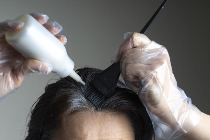 A woman dyeing her roots