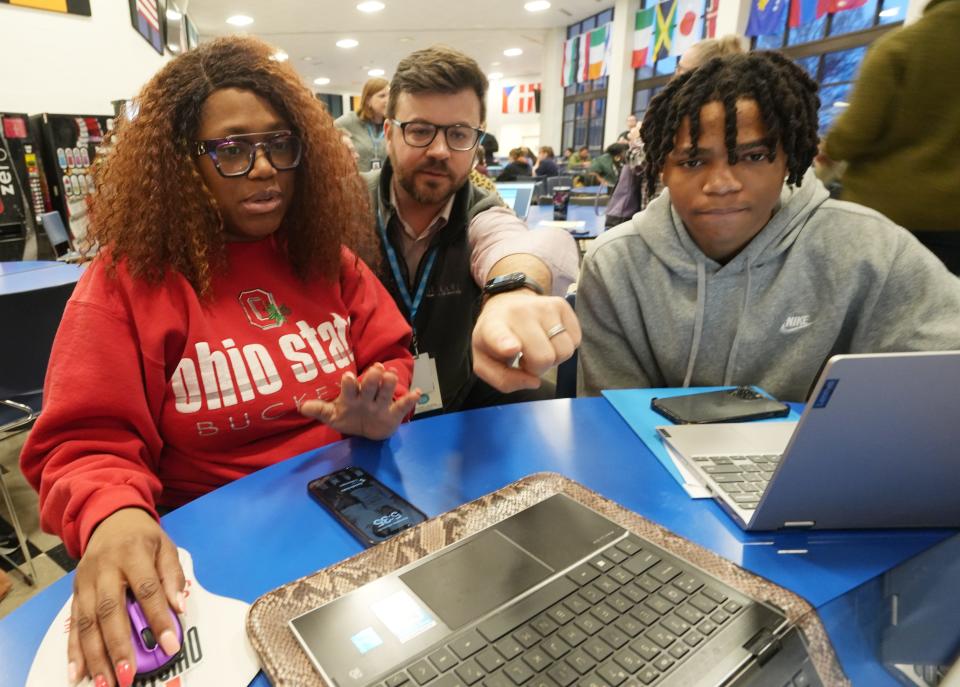 Patrick Lynchm, director of development for I Know I Can, helps Tomica Livingston and her son, Myles, during a FAFSA Night on Jan. 24 at Central Crossing High School. I Know I Can sponsored the Jan. 24, 2024, workshop where students can fill out their FAFSA forms with help from advisers.