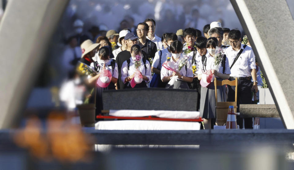 Visitors pay in front of the cenotaph dedicated to the victims of the atomic bombing at the Hiroshima Peace Memorial Park in Hiroshima, western Japan Sunday, Aug. 6, 2023. Hiroshima marked the 78th anniversary of the world's first atomic bombing of the city. (Kyodo News via AP)