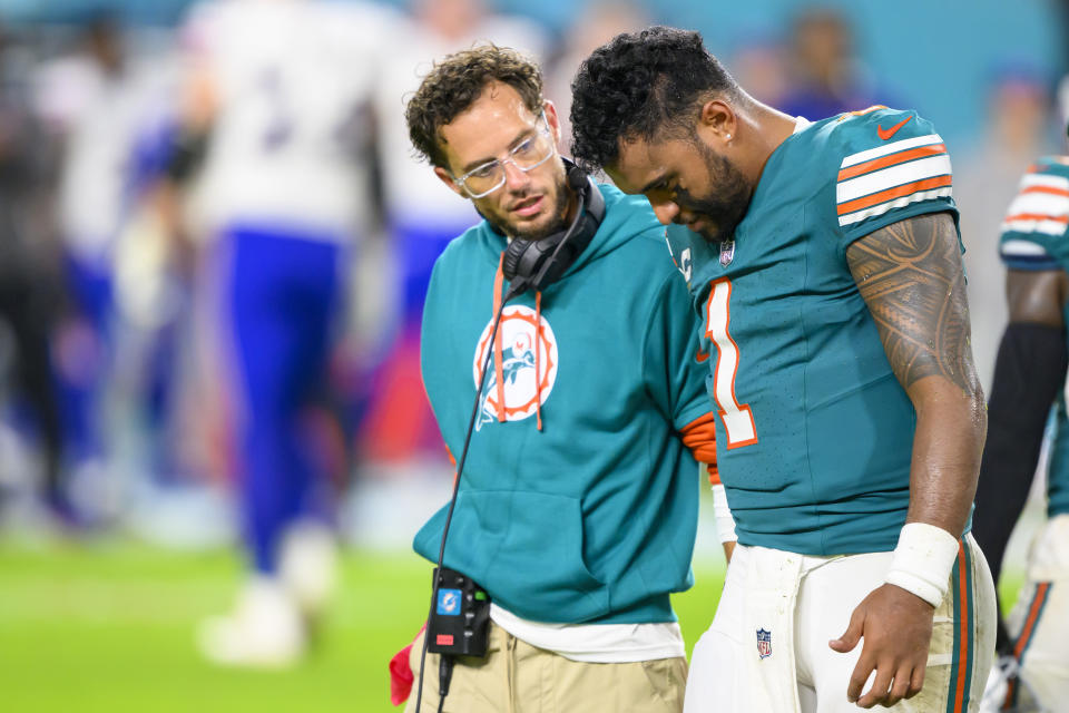 Tua Tagovailoa walks off of the field with Dolphins head coach Mike McDaniel after suffering a concussion Thursday night. (AP Photo/Doug Murray)