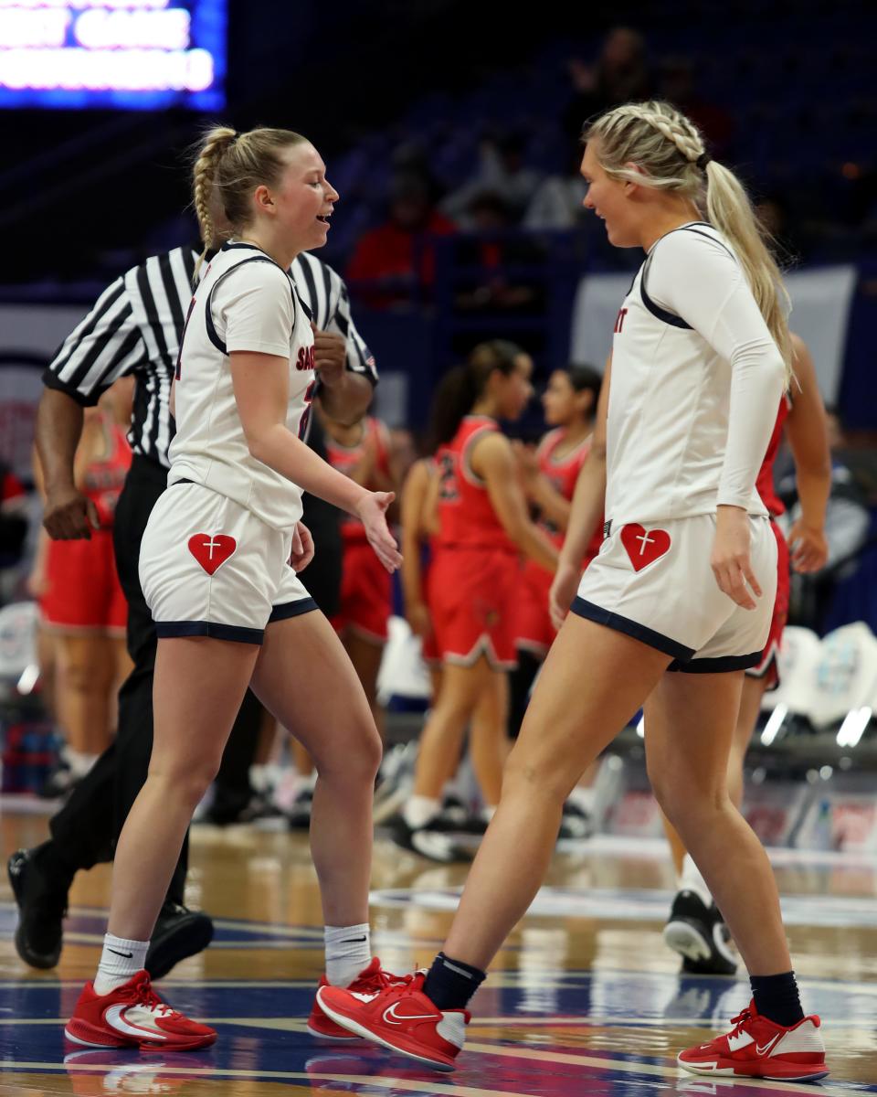 Sacred Heart’s Reagan Bender and Abigail Wolff celebrate with teammates after defeating George Rogers Clark in the 2023 Mingua Beef Jerky Girls’ Sweet 16.March 11, 2023