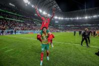 Morocco's Hakim Ziyech, top, celebrates with his teammate Morocco's Zakaria Aboukhlal their team victory at end of the World Cup round of 16 soccer match between Morocco and Spain, at the Education City Stadium in Al Rayyan, Qatar, Tuesday, Dec. 6, 2022. (AP Photo/Martin Meissner)