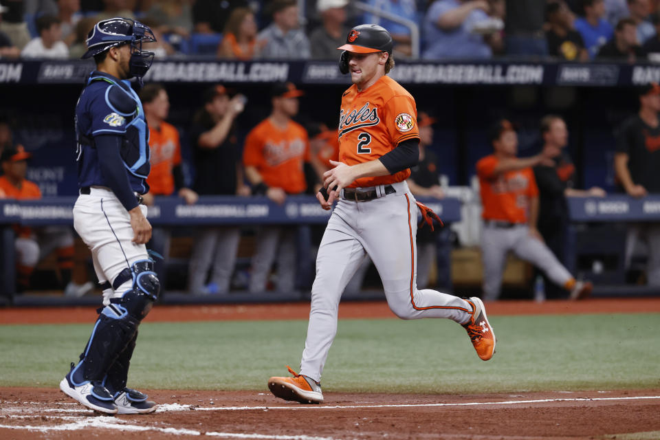 Baltimore Orioles' Gunnar Henderson runs past Tampa Bay Rays' Rene Pinto to score during the fourth inning of a baseball game Saturday, July 22, 2023, in St. Petersburg, Fla. (AP Photo/Scott Audette)