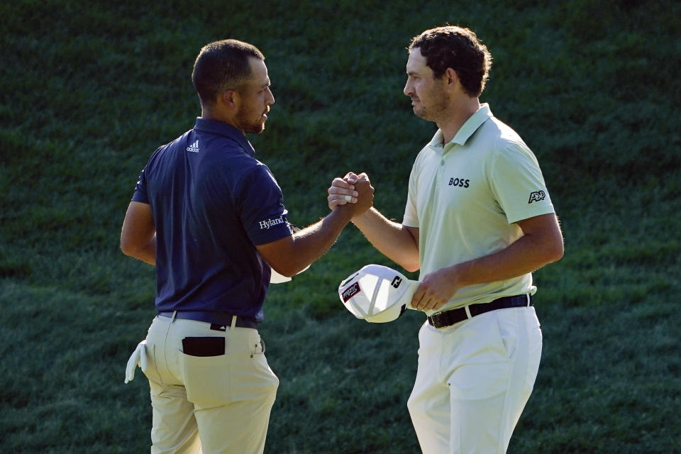 Xander Schauffele, left, and Patrick Cantlay shake hands after finishing the third round of the Travelers Championship golf tournament at TPC River Highlands, Saturday, June 25, 2022, in Cromwell, Conn. Schauffele finished one stroke ahead of Cantley for the lead heading into the final round on Sunday. (AP Photo/Seth Wenig)