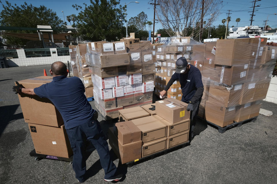 FILE - Workers load pallets with boxes of medical supplies to aid Ukrainians from Dignity Health - Northridge Hospital Medical Center in Los Angeles on March 10, 2022. When Russian forces two months ago launched a military campaign against infrastructure in Ukraine, it opened an urgent second front far from the contact line: along power lines, water mains, and heating systems, and in places like homes, schools, offices and churches. (AP Photo/Richard Vogel, File)