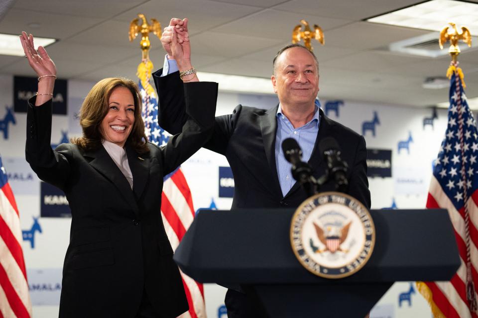 TOPSHOT - US Vice President and Democratic presidential candidate Kamala Harris and Second Gentleman Doug Emhoff acknowledge the crowd before speaking at her campaign headquarters in Wilmington, Delaware, on July 22, 2024. Harris on January 22, won the crucial backing of Democratic heavyweight Nancy Pelosi to lead the party against Donald Trump in November after Joe Biden's stunning exit from the 2024 race. As the endorsements stacked up, the 59-year-old Harris made her first public appearance since Biden's announcement in a ceremony at the White House where she warmly praised the outgoing president's "unmatched" achievements. (Photo by Erin SCHAFF / POOL / AFP) (Photo by ERIN SCHAFF/POOL/AFP via Getty Images)