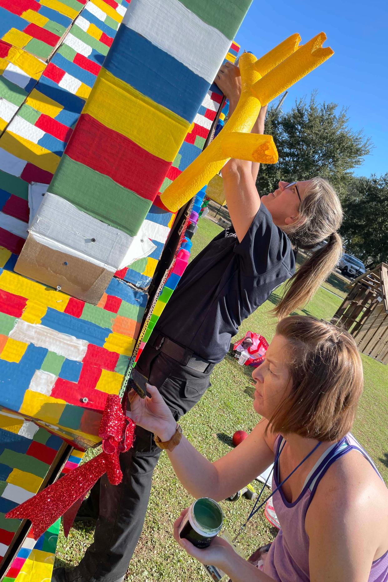 Jessie Edwards and Sheila Merier with the Fort Walton Beach Police Department work on their Lego-themed Christmas house in preparation for the department's annual "Winter Wonderland" community night out event on Friday, Dec. 9 from 6 p.m. to 10 p.m.