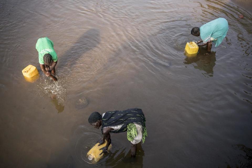 In this photo taken Thursday, March 9, 2017, women fill jerrycans of river water to take back to their homes in Torit, in South Sudan. As World Water Day approaches on March 22, more than 5 million people in South Sudan, do not have access to safe, clean water, compounding the problems of famine and civil war, according to the UNICEF. (Mackenzie Knowles-Coursin/UNICEF via AP)