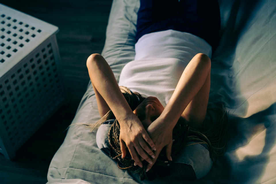 Portrait of a dreadlocks braid topknot bun woman lying and sleeping on the sofa. Concept of depression, loneliness, problems of adolescence