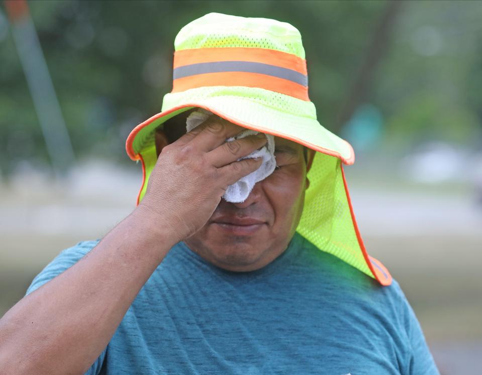 Ismael tries to find some relief from the heat as he takes a break from the mason work he's doing at the restaurant Sakura in Parsippany, NJ on August 4, 2022.