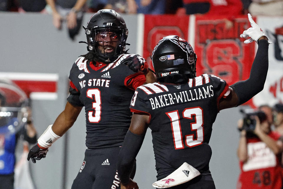 North Carolina State's Aydan White (3) celebrates his touchdown with teammate Tyler Baker-Williams (13) following his interception during the first half of an NCAA college football game against Texas Tech in Raleigh, N.C., Saturday, Sept. 17, 2022. (AP Photo/Karl B DeBlaker)