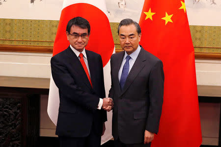 Japanese Foreign Minister Taro Kono, left, and Chinese counterpart Wang Yi pose for photograph before their meeting at the Diaoyutai State Guesthouse in Beijing, China Jan. 28, 2018. REUTERS/Andy Wong/Pool