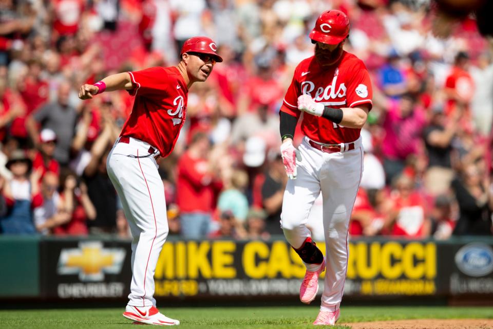 Cincinnati Reds third base/catching coach J.R. House (56) celebrates as Cincinnati Reds first baseman Colin Moran (16) heads home after hitting a grand slam in the sixth inning of the MLB game between the Cincinnati Reds and the Pittsburgh Pirates at Great American Ball Park in Cincinnati on Sunday, May 8, 2022.