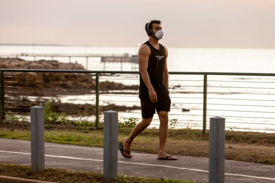 A man in a mask exercise outside in Darwin.