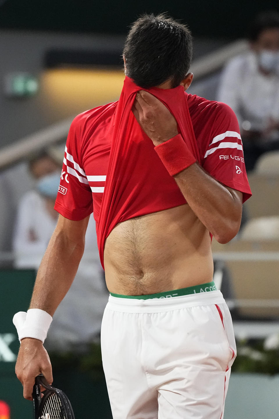 Serbia's Novak Djokovic wipes his face as he plays Spain's Rafael Nadal during their semifinal match of the French Open tennis tournament at the Roland Garros stadium Friday, June 11, 2021 in Paris. (AP Photo/Michel Euler)