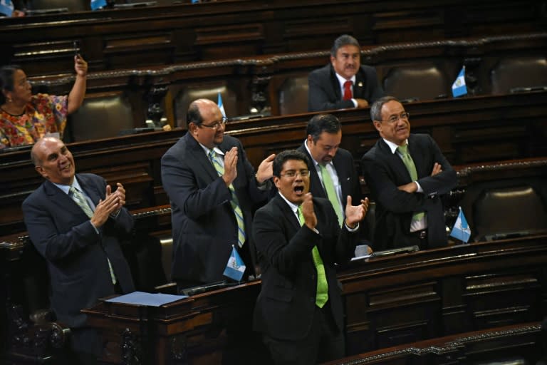 Guatemalan congressmen celebrate after voting unanimously to strip embattled President Otto Perez's immunity in Guatemala City on September 1, 2015