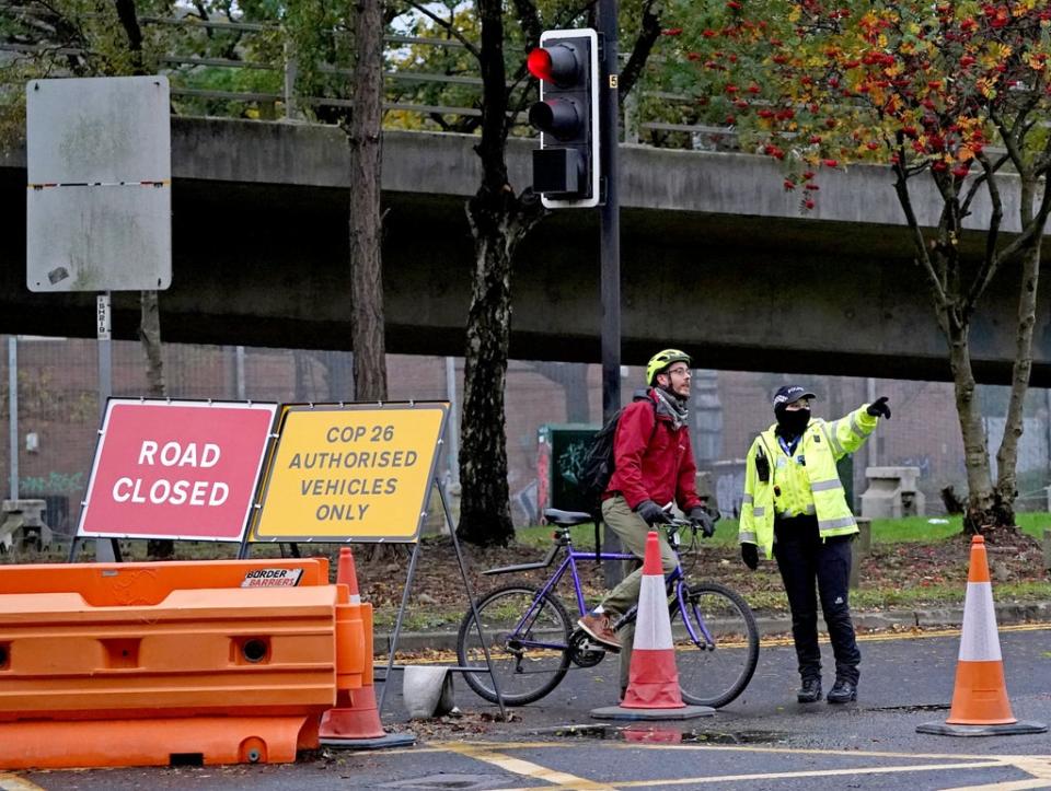 A police officer gives directions to a cyclist away from the roadblock at the entrance to the Clydeside Express in the centre of Glasgow (Andrew Milligan/PA) (PA Wire)