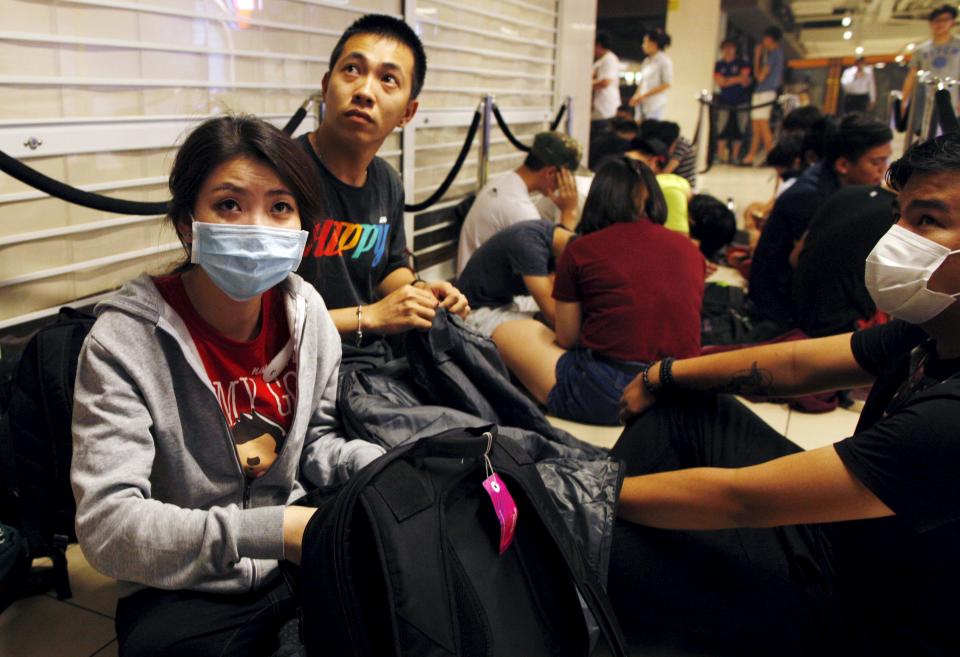 People wearing masks for the haze queue overnight for the launch of the new Apple iPhone 6s mobile phone at a mall in Singapore