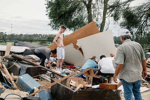 People sift through debris at a damaged home after Hurricane Laura made landfall in Cameron Parish, Louisiana.