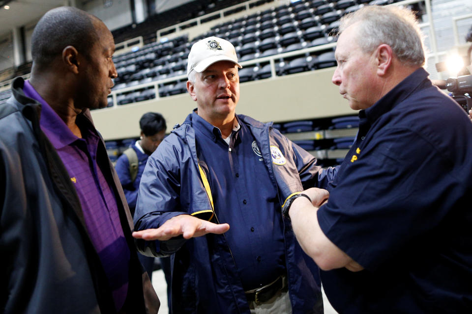 Gov. John Bel Edwards talks with two officials from Calcasieu Parish in August 2017.