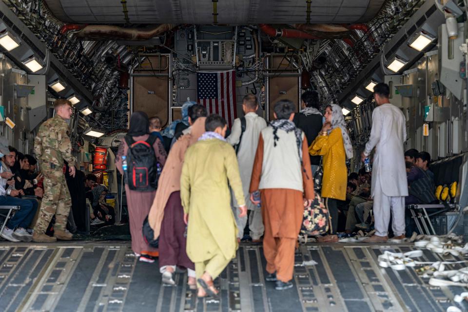 A U.S. Air Force loadmaster, assigned to the 816th Expeditionary Airlift Squadron, assists evacuees aboard a C-17 Globemaster III aircraft in support of Operation Allies Refuge at Hamid Karzai International Airport, Kabul, Afghanistan, on Aug. 20.