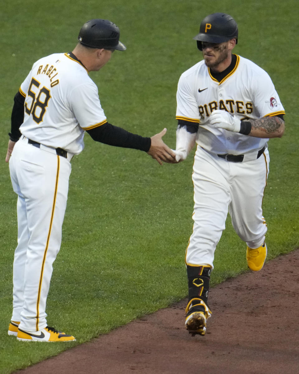 Pittsburgh Pirates' Yasmani Grandal, right, is greeted by third base coach Mike Rabelo (58) as Grandal rounds third on a three-run home run off Chicago Cubs pitcher Keegan Thompson during the fifth inning of a baseball game in Pittsburgh, Saturday, May 11, 2024. (AP Photo/Gene J. Puskar)