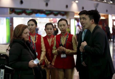 Airport officials talk to Ursula Gauthier, a reporter for the French current affairs magazine L'Obs, at Beijing international airport before her departure to France, in Beijing December 31, 2015. REUTERS/Kim Kyung-Hoon