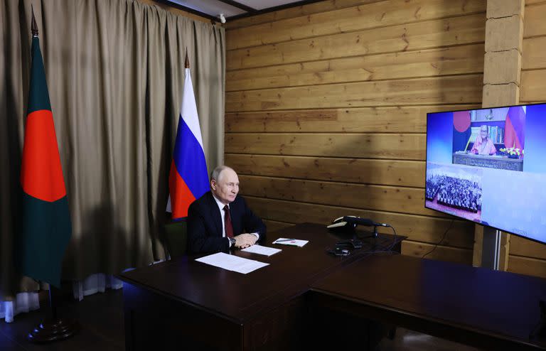Esta fotografía de grupo distribuida por la agencia estatal rusa Sputnik muestra al presidente ruso, Vladímir Putin, asistiendo a una ceremonia por vídeo dedicada a la primera entrega de uranio para la planta nuclear respaldada por Rusia en Rooppur, en Bangladesh, en Sochi, el 5 de octubre de 2023. (Foto de Mikhail METZEL / POOL / AFP)