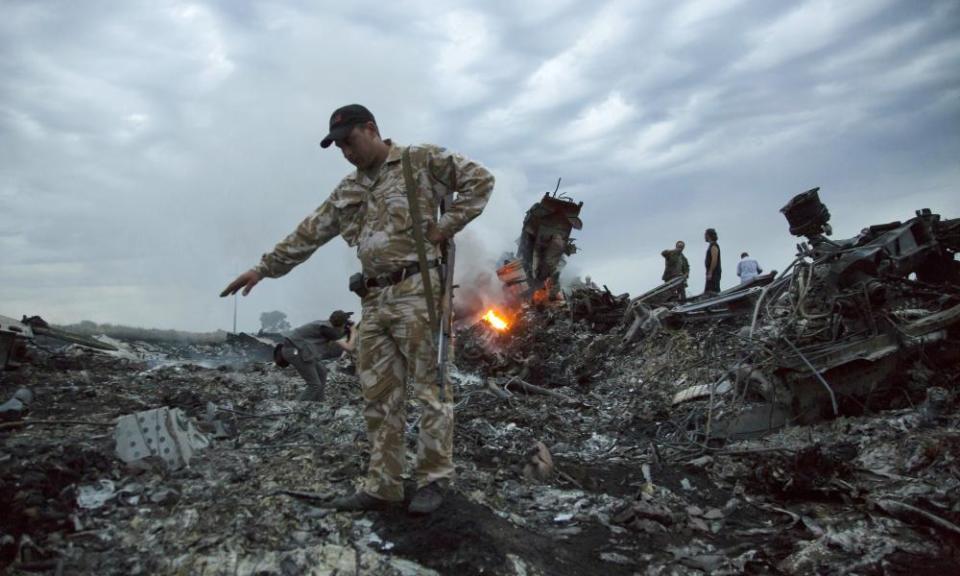 People walking among the debris at the crash site of MH17 in July 2014.