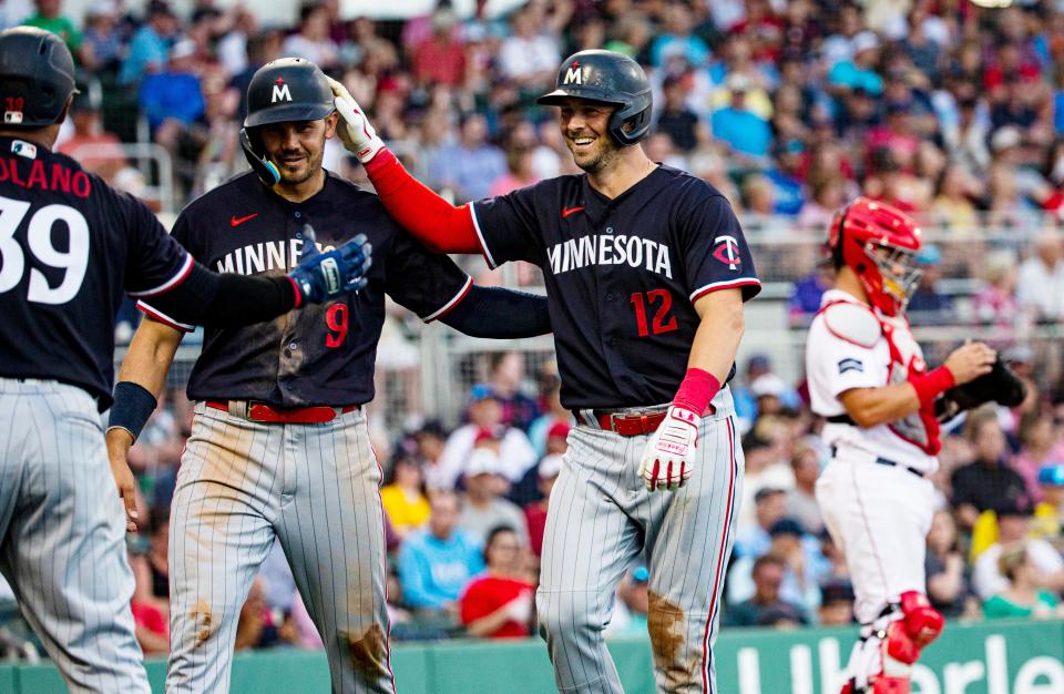 Kyle Farmer, right,  of the Minnesota Twins is congratulated by Trevor Larnach, center, after hitting a home run against the Boston Red Sox during a spring training game at Jet Blue Park on Wednesday, March 22, 2023. The Twins won 11-0.