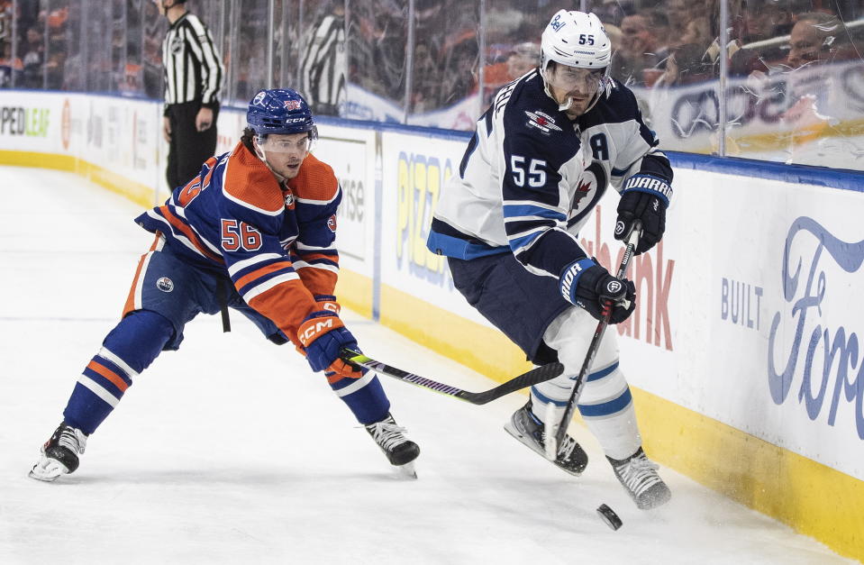 Winnipeg Jets' Mark Scheifele (55) and Edmonton Oilers' Kailer Yamamoto (56) vie for the puck during the first period of an NHL hockey game Friday, March 3, 2023, in Edmonton, Alberta. (Jason Franson/The Canadian Press via AP)