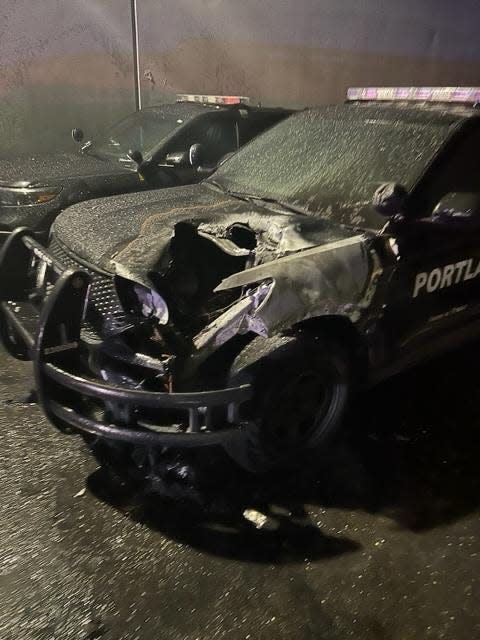 Pictured is a black Portland Police Bureau vehicle with heavy fire damage to left front quarter.