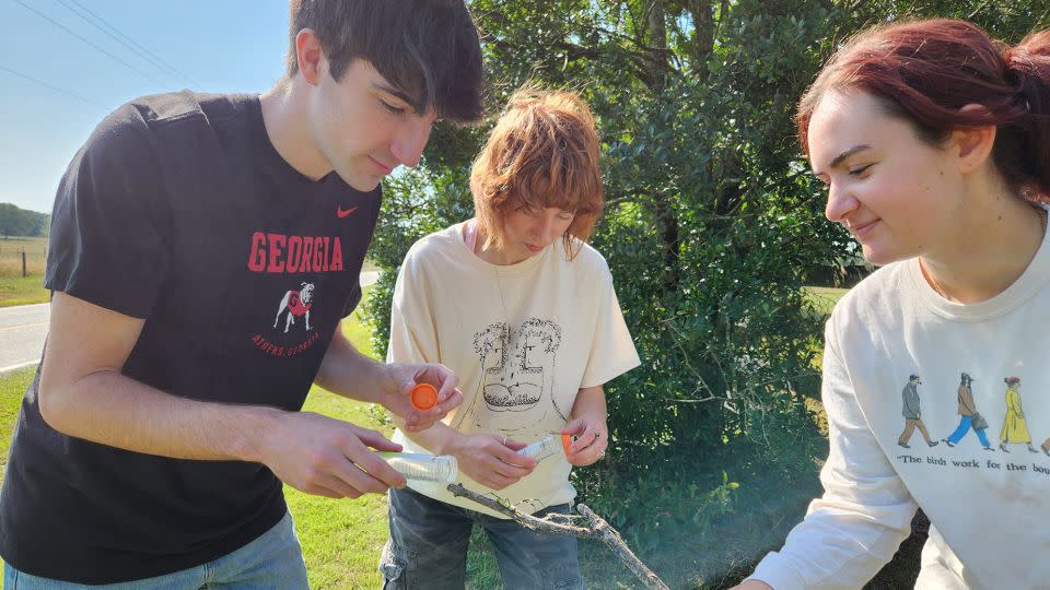 University of Georgia ecology students and study coauthors Kade Stewart, Caitlin Phelan and Alexa Schultz handle a Jorō spider. - Andy Davis