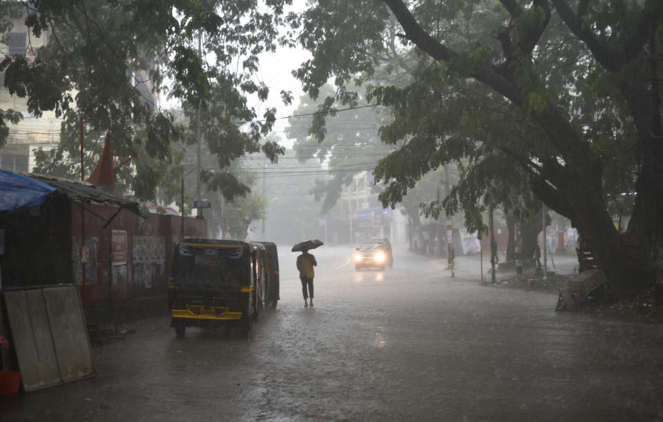 A man walks holding an umbrella as it rains in Kochi, Kerala state, India, Thursday, May 28, 2020. India sees no respite from the coronavirus caseload at a time when the two-month-old lockdown across the country is set to end on Sunday. (AP Photo/R S Iyer)