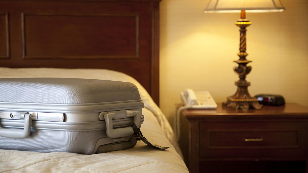  A suitcase on top of a mattress in a hotel room. 