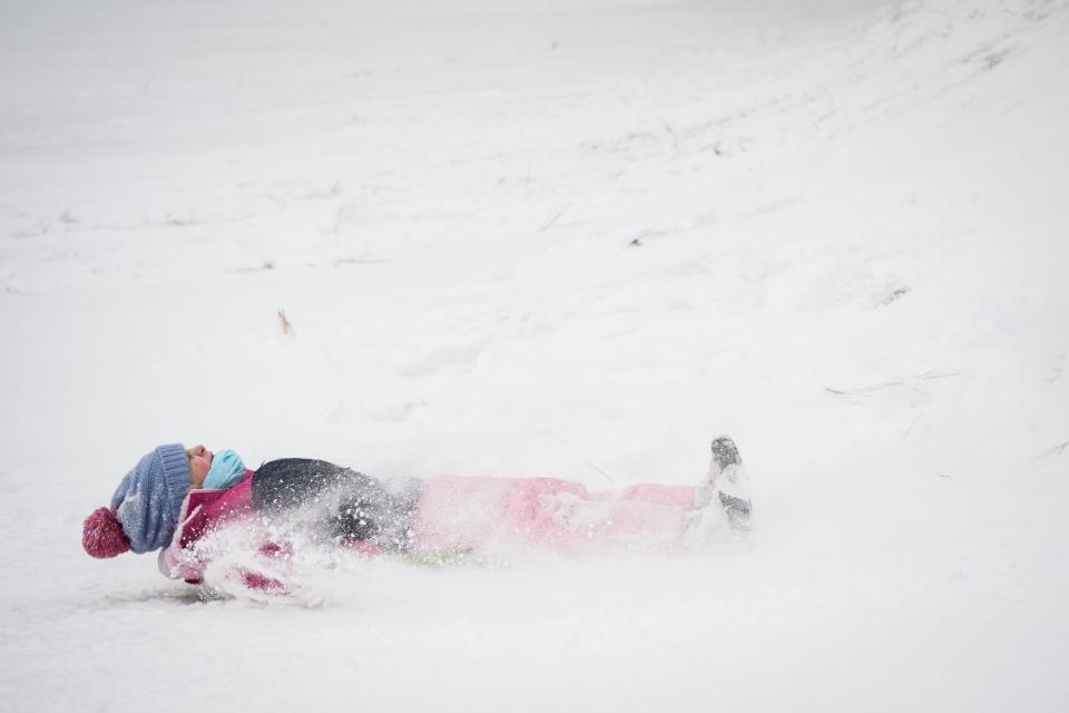 Savanah Davis, 6, spins as she sleds down a hill at Highland Country Club in Fayetteville on Saturday, Jan. 22, 2022.