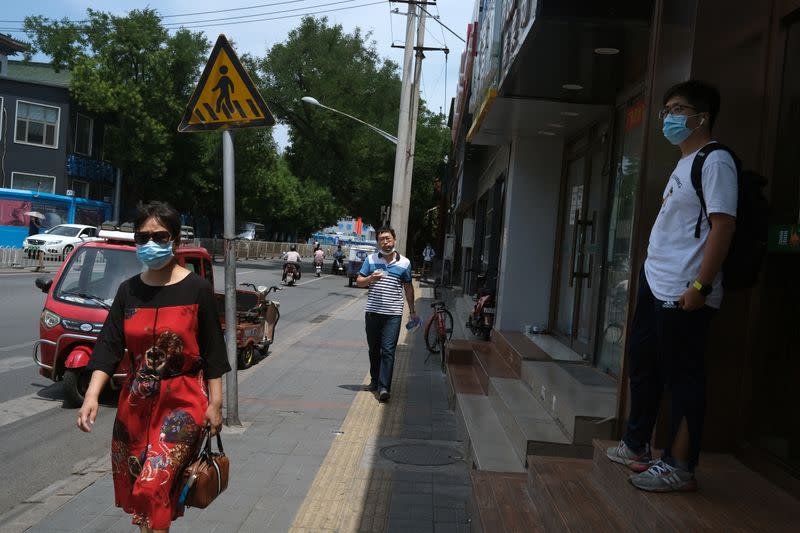 People wearing face masks are seen on a street, following the outbreak of the coronavirus disease (COVID-19), in Beijing(COVID-19), in Beijing