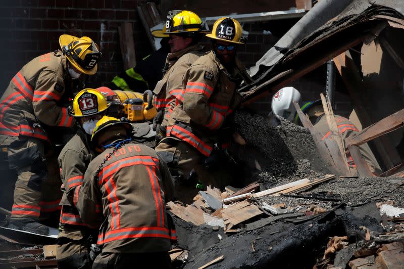 Fire fighters look for survivors at the scene of an explosion in a residential area of Baltimore