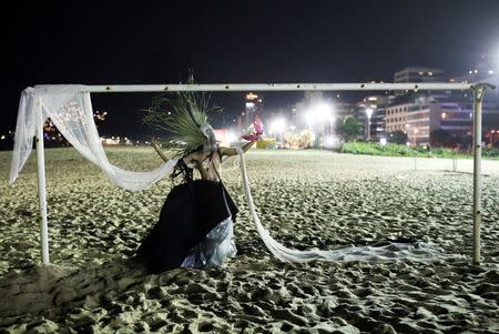 2016 Rio Olympics - Rio de Janeiro, Brazil - 14/08/2016. Murilo Sousa, 25, poses on a goal before a mermaid competition at Ipanema beach. REUTERS/Nacho Doce