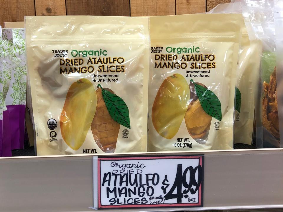 Packages of organic dried Ataulfo mango slices at Trader Joe's, with a price tag that reads $4.99.